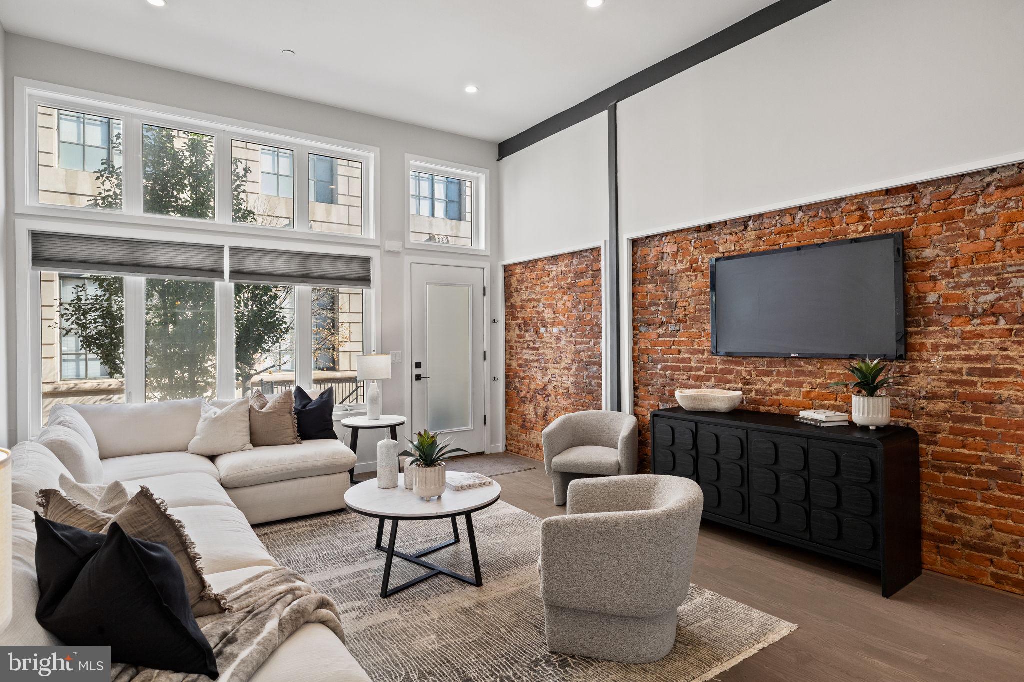 2106 Spring Street Philadelphia, PA 19103 - Photo 7 of 68 a living room with furniture a flat screen tv and a floor to ceiling window