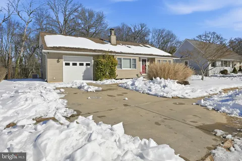 a view of a house with a yard covered in snow