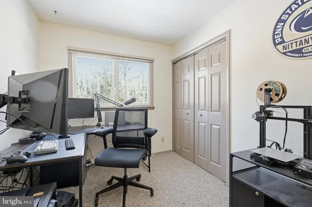 a view of a workspace with furniture and a window