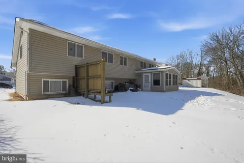 a front view of a house with a yard covered in snow