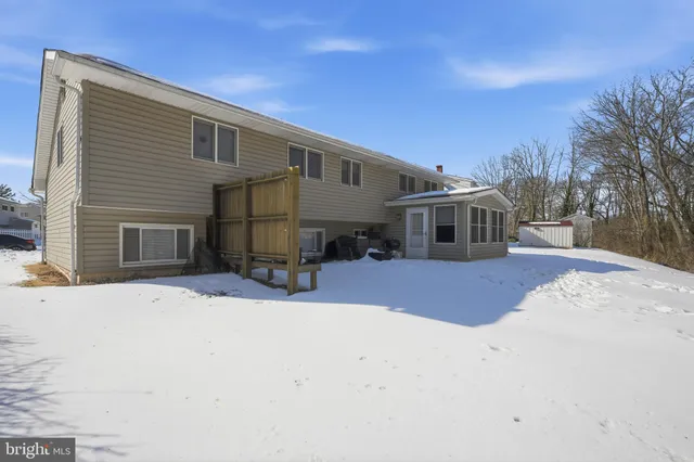 a front view of a house with a yard covered in snow