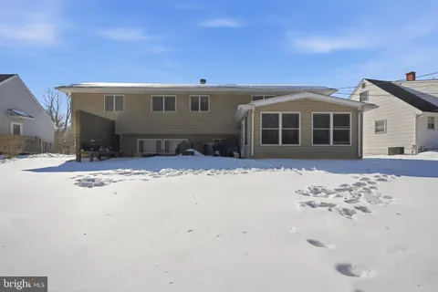 a front view of a house with a yard covered in snow