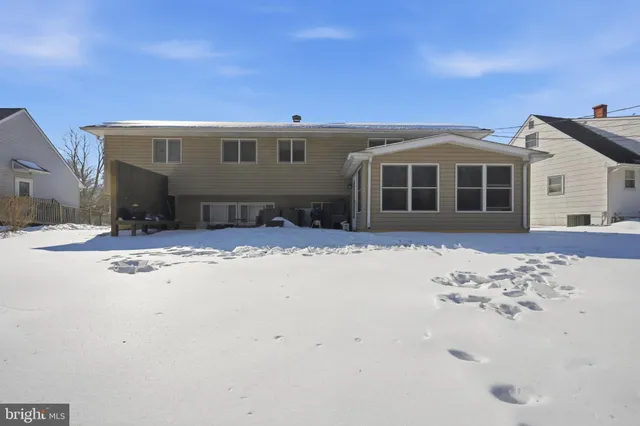 a front view of a house with a yard covered in snow