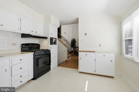 a kitchen with white cabinets and white appliances