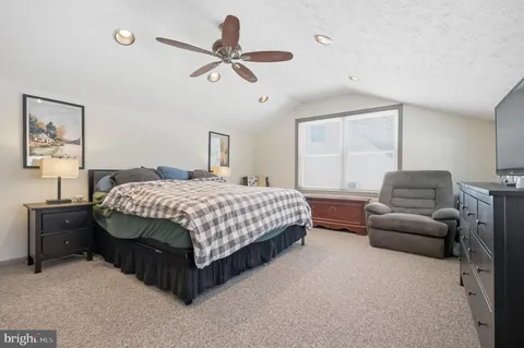 a bedroom with a bed a couch and a window