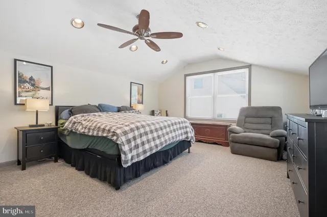 a bedroom with a bed a couch and a window