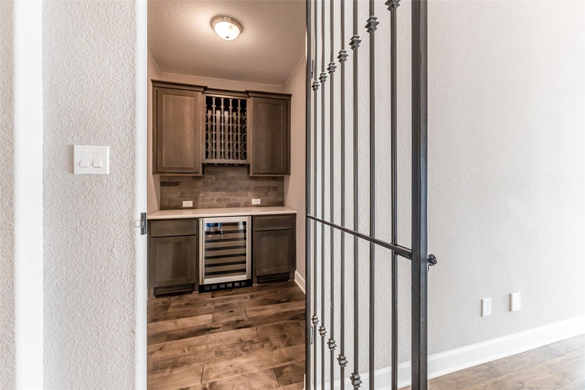 1050 Groveton Ridge Lane Pinehurst, TX 77362 - Photo 12 of 50 Wine grotto with wine fridge, counters, cabinets and wine glass rack.