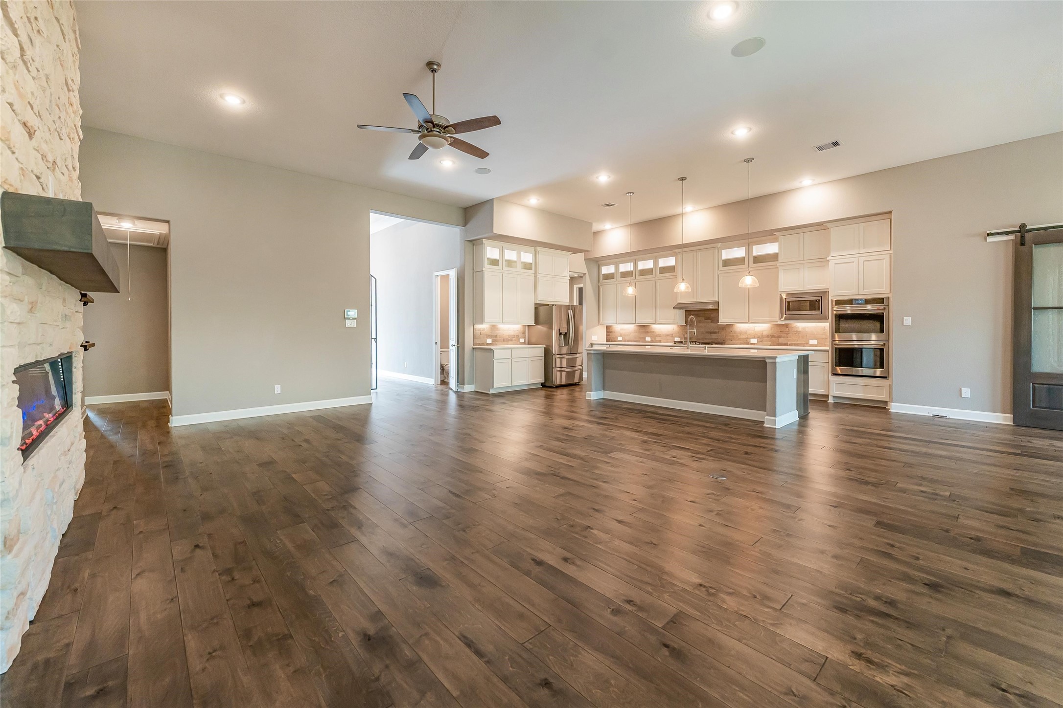 1050 Groveton Ridge Lane Pinehurst, TX 77362 - Photo 17 of 50 a view of a big room with wooden floor a ceiling fan and windows