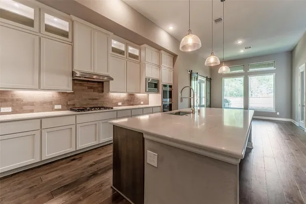 a view of a kitchen with cabinets and wooden floor