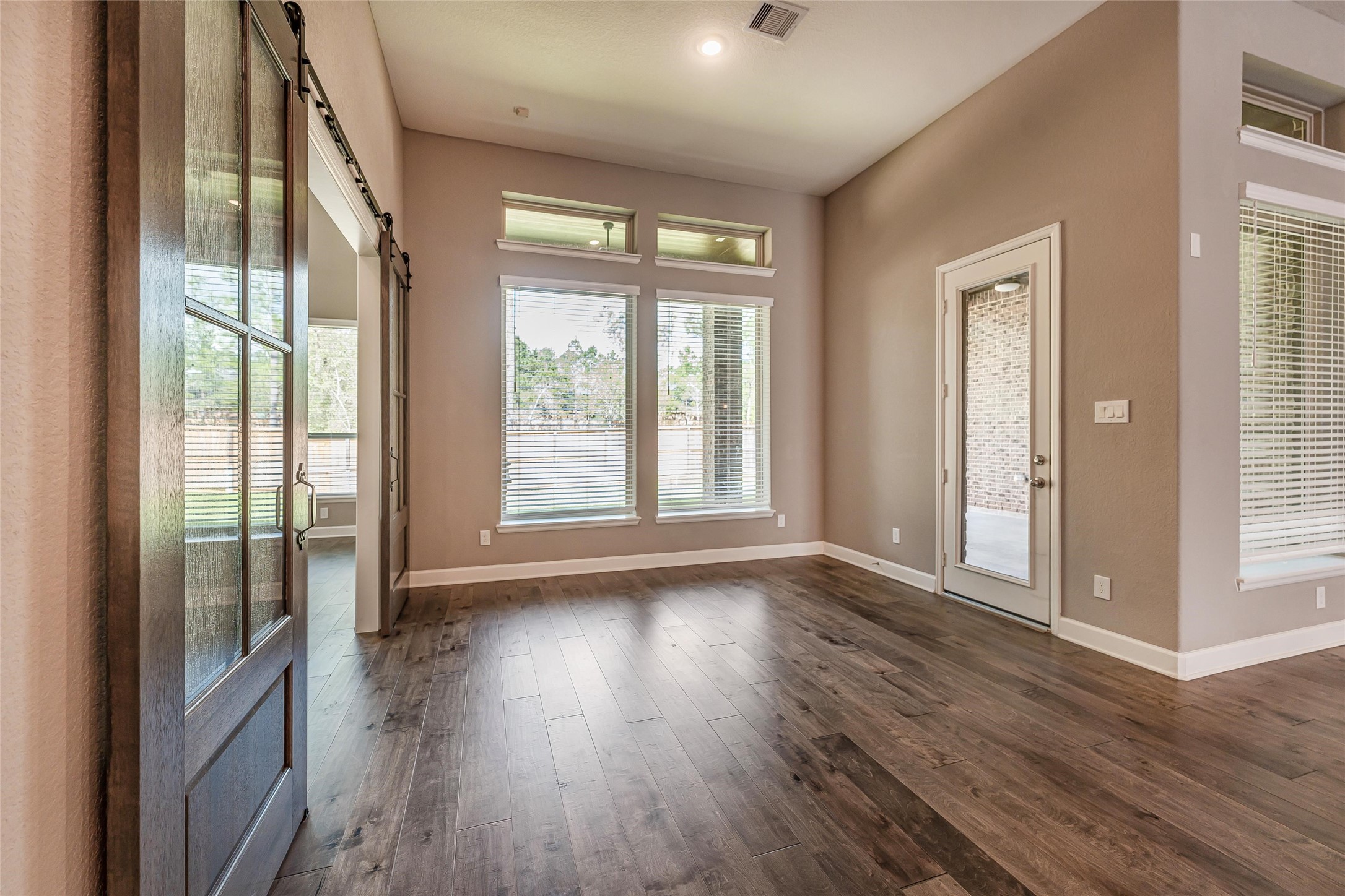 1050 Groveton Ridge Lane Pinehurst, TX 77362 - Photo 21 of 50 a view of an empty room with wooden floor and a window
