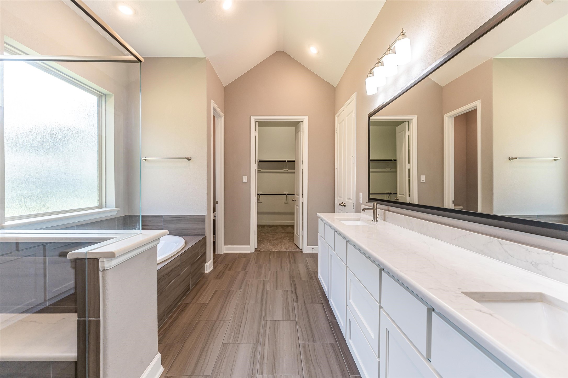 1050 Groveton Ridge Lane Pinehurst, TX 77362 - Photo 30 of 50 a spacious bathroom with a granite countertop sink a large mirror and a bathtub