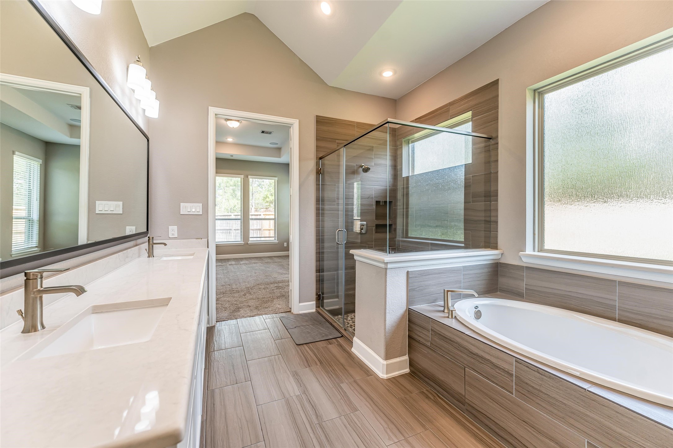 1050 Groveton Ridge Lane Pinehurst, TX 77362 - Photo 32 of 50 a bathroom with a large tub a sink and glass door shower