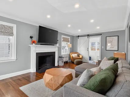 a living room with furniture a flat screen tv and a fireplace