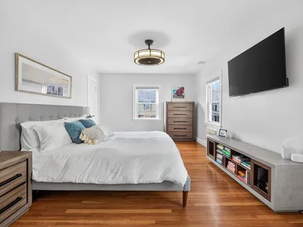 a bedroom with a bed and wooden floor