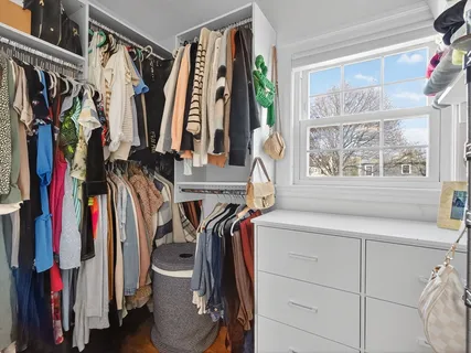 a bathroom with a granite countertop toilet a sink and a window