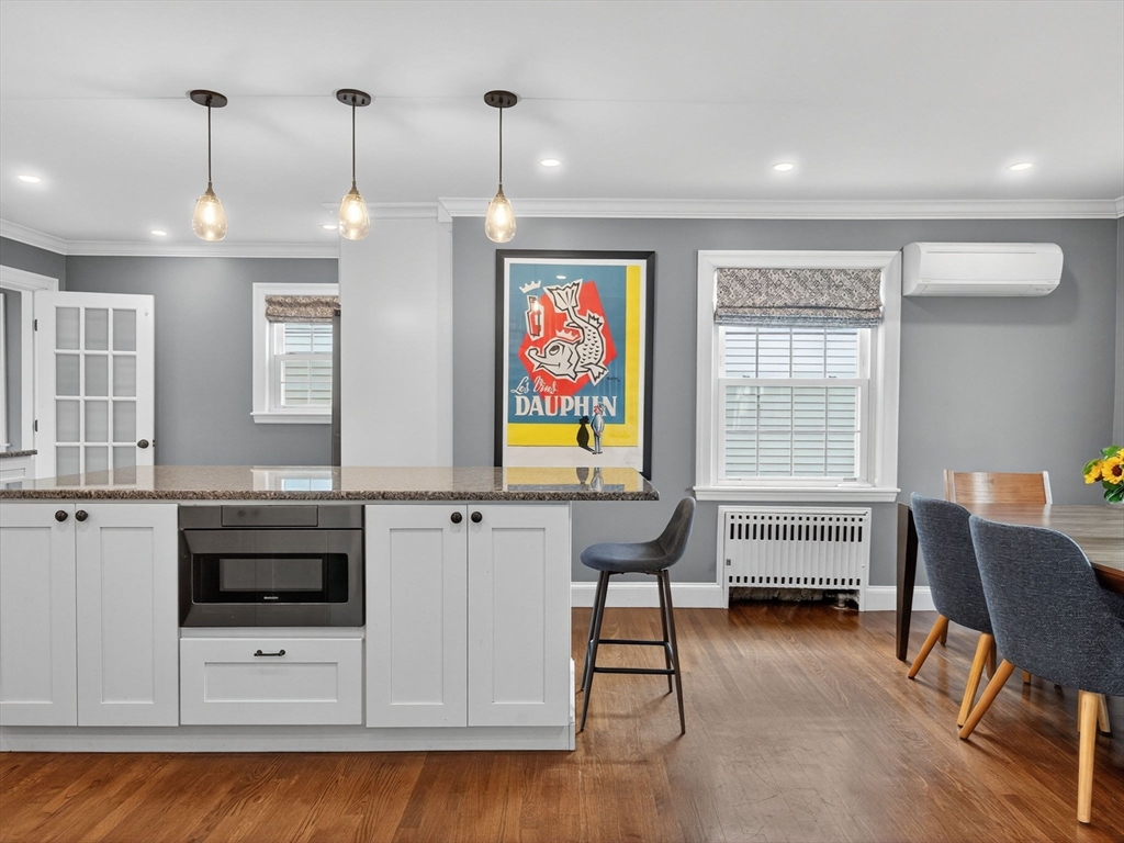 37 Rangeley Street Boston, MA 02124 - Photo 4 of 26 a view of a kitchen with stainless steel appliances wooden floor dining table and chairs