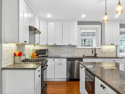 a kitchen with stainless steel appliances granite countertop a sink stove and cabinets