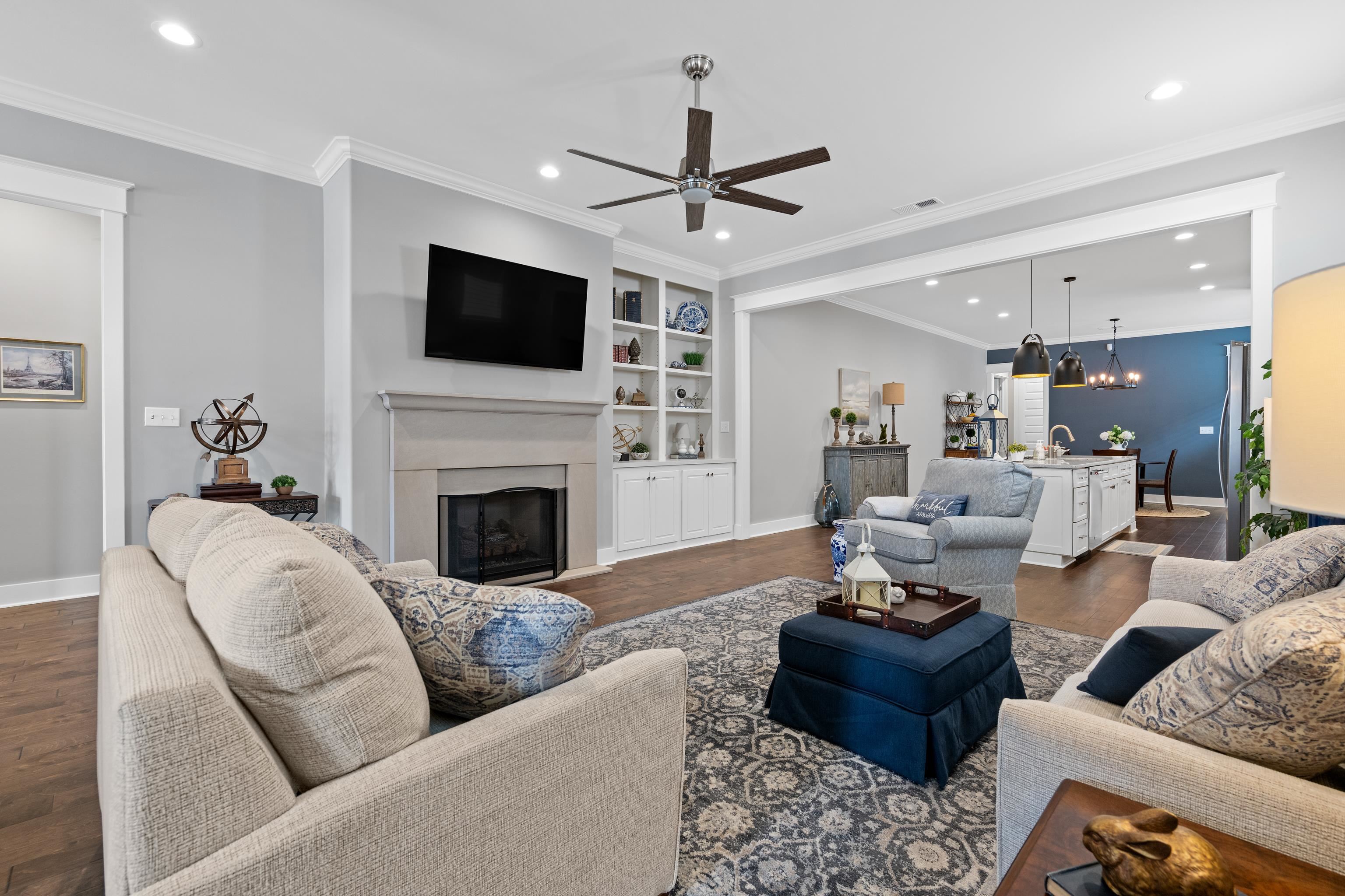502 South Shea Road Collierville, TN 38017 - Photo 12 of 40 Living room with ornamental molding, dark hardwood / wood-style flooring, ceiling fan with notable chandelier, and built in features