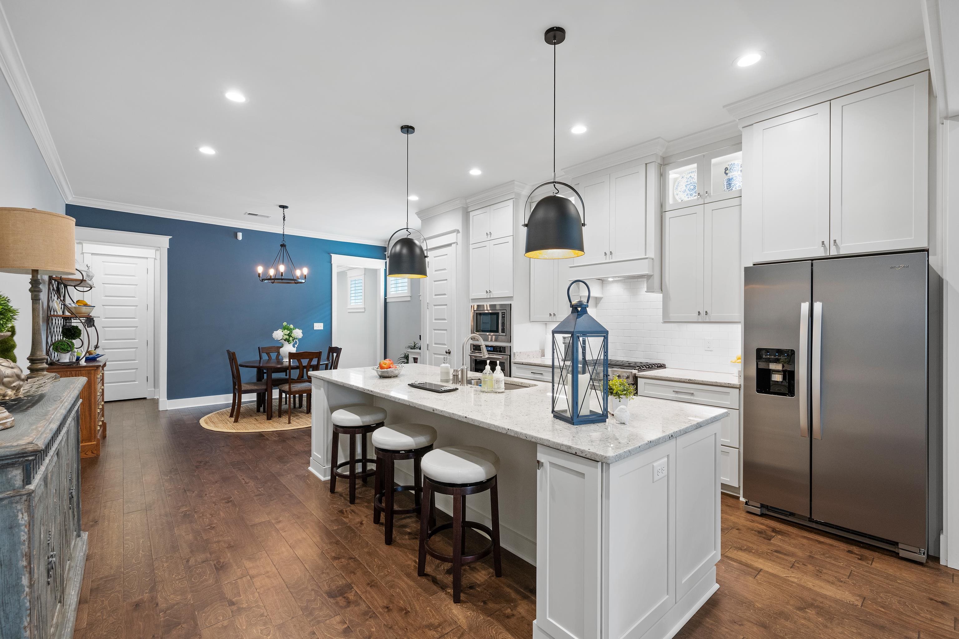 502 South Shea Road Collierville, TN 38017 - Photo 13 of 40 Kitchen featuring appliances with stainless steel finishes, white cabinets, dark hardwood / wood-style floors, and a kitchen island with sink