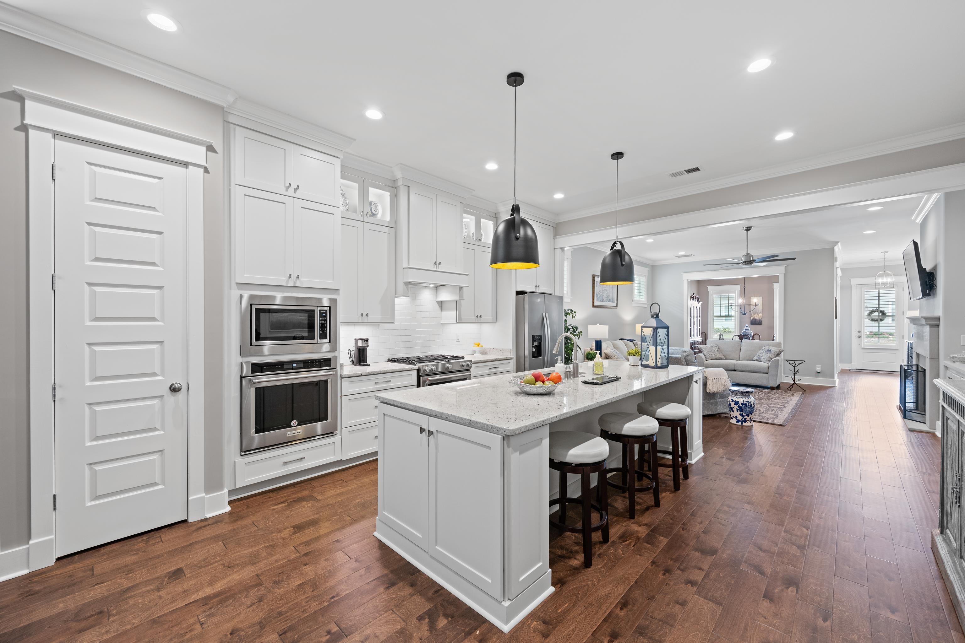 502 South Shea Road Collierville, TN 38017 - Photo 15 of 40 Kitchen featuring white cabinetry, crown molding, a center island with sink, appliances with stainless steel finishes, and dark wood-type flooring
