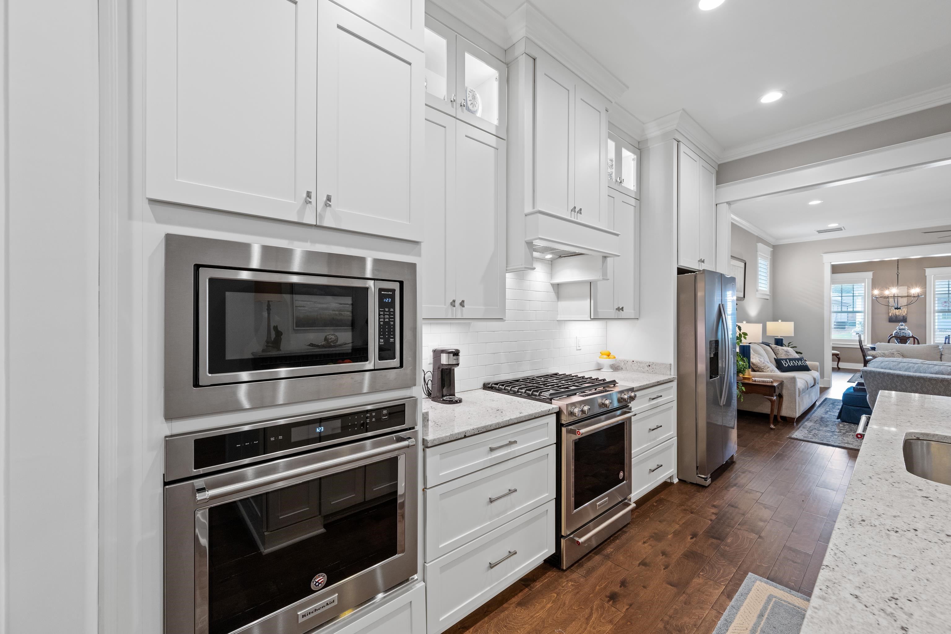 502 South Shea Road Collierville, TN 38017 - Photo 16 of 40 Kitchen featuring crown molding, white cabinets, dark hardwood / wood-style floors, stainless steel appliances, and light stone countertops
