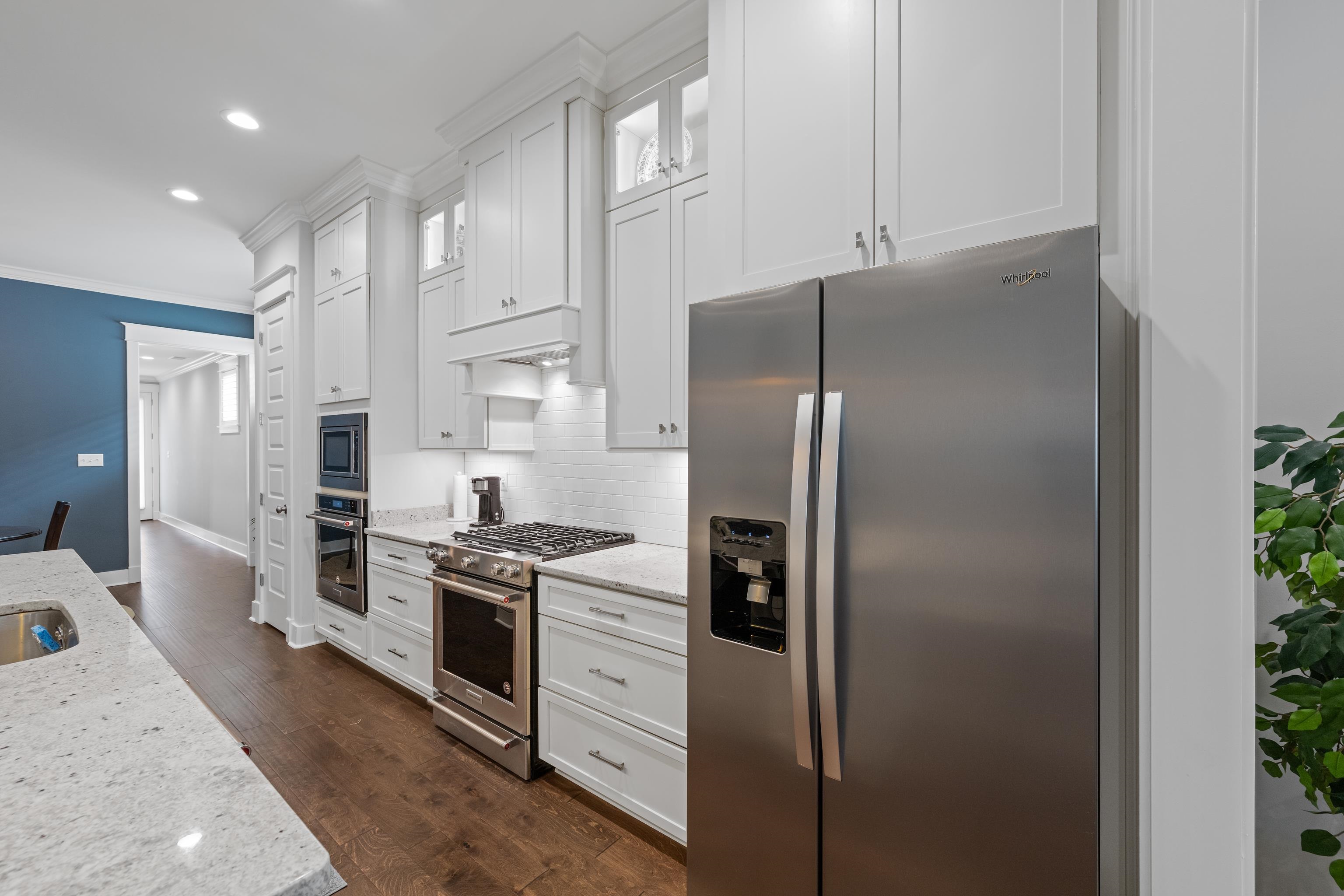 502 South Shea Road Collierville, TN 38017 - Photo 17 of 40 Kitchen featuring white cabinets, decorative backsplash, light stone counters, dark hardwood / wood-style floors, and appliances with stainless steel finishes