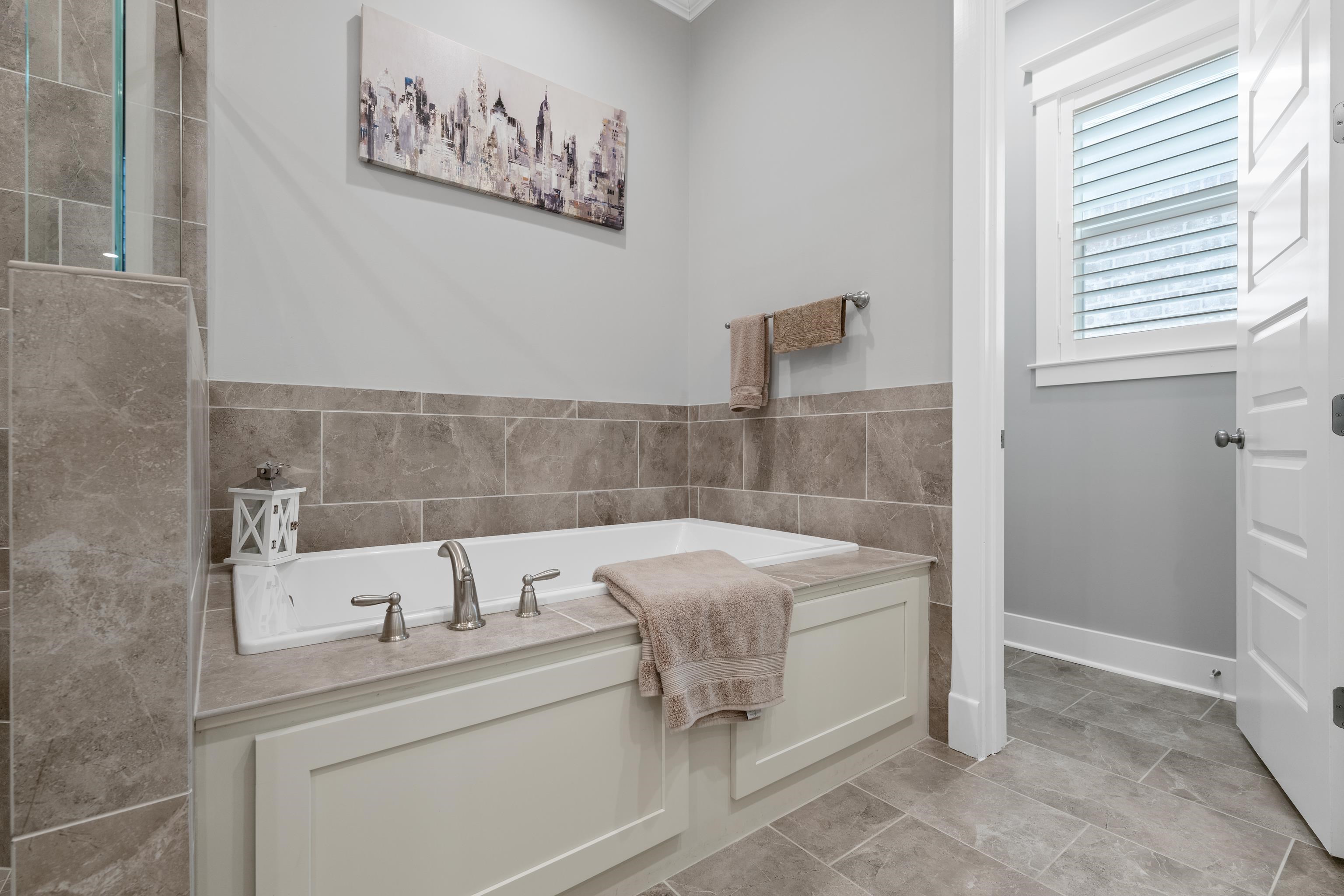 502 South Shea Road Collierville, TN 38017 - Photo 24 of 40 Bathroom with tile patterned flooring, tile walls, and a bath