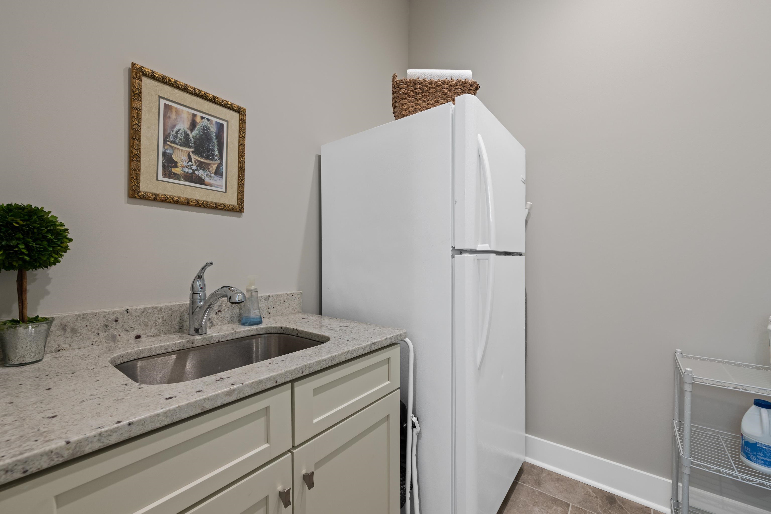 502 South Shea Road Collierville, TN 38017 - Photo 31 of 40 Kitchen with white fridge, light tile patterned floors, white cabinets, light stone countertops, and sink