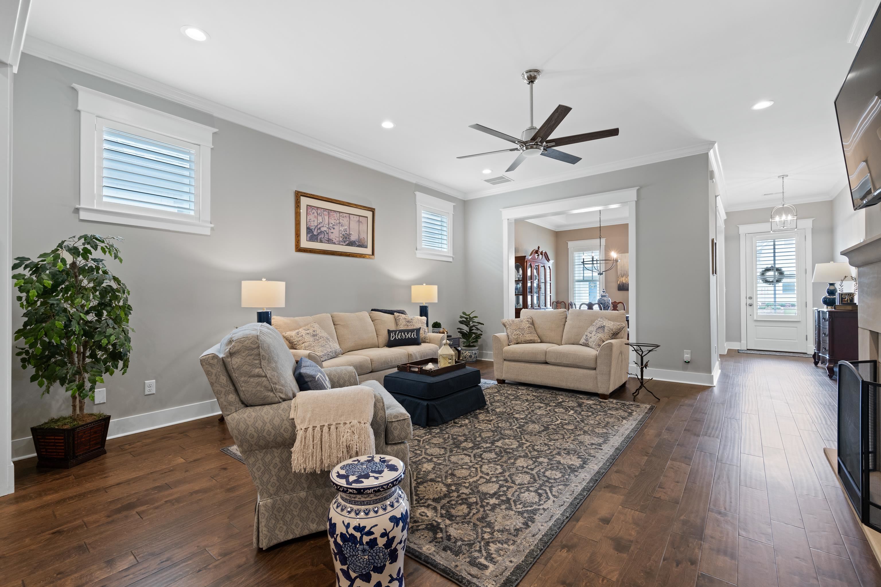 502 South Shea Road Collierville, TN 38017 - Photo 9 of 40 Living room featuring a wealth of natural light, dark wood-type flooring, ceiling fan with notable chandelier, and ornamental molding