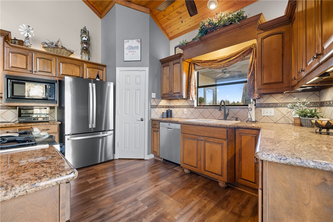2250 Dillard Road Washington, TX 77880 - Photo 15 of 50 a kitchen with stainless steel appliances granite countertop a refrigerator a stove and a sink with wooden floor