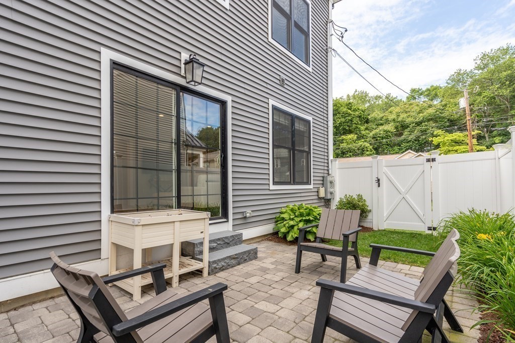 33 Riverside Street, Unit 33 Needham, MA 02494 - Photo 17 of 22 a backyard of a house with table and chairs