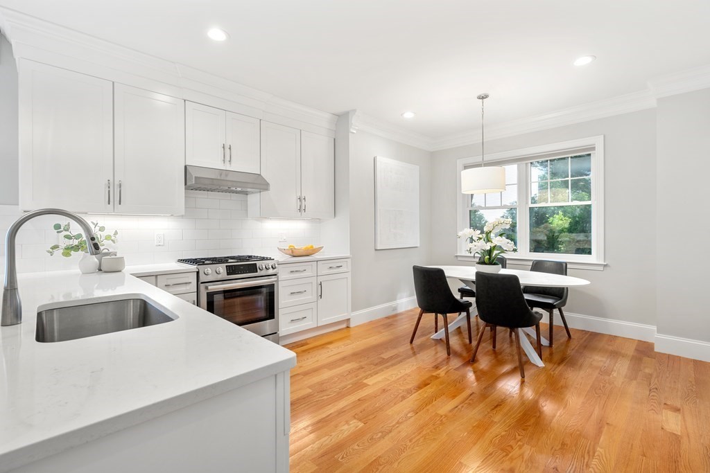 33 Riverside Street, Unit 33 Needham, MA 02494 - Photo 6 of 22 a kitchen with stainless steel appliances a stove a sink a microwave a dining table and chairs