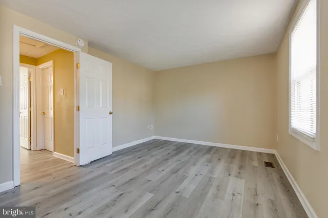 an empty room with wooden floor and a window