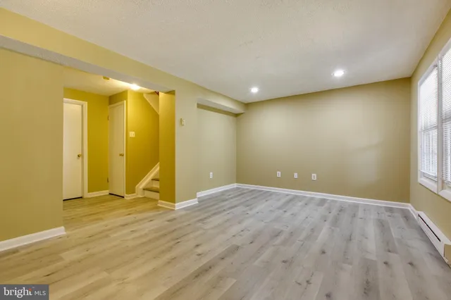 a view of empty room with wooden floor