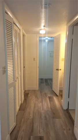 an empty room with wooden floor and a bathroom