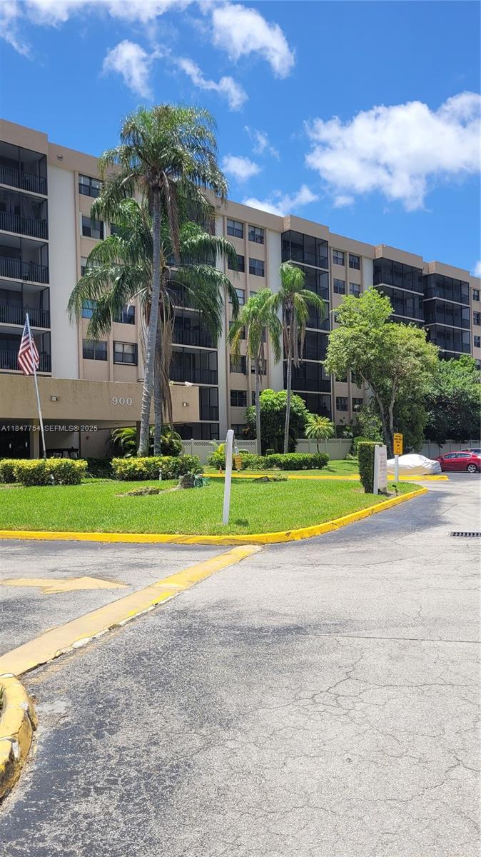 900 Northeast 195th Street, Unit 620 Miami, FL 33179 - Photo 3 of 28 a view of a house with a swimming pool and a yard