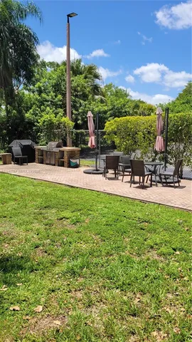 a view of a swimming pool with lawn chairs and plants
