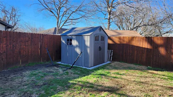 a view of backyard with barn and wooden fence