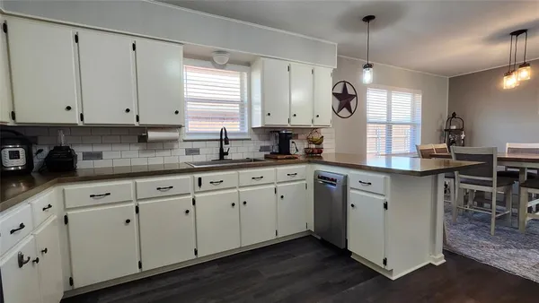 a kitchen with cabinets appliances a sink and a window