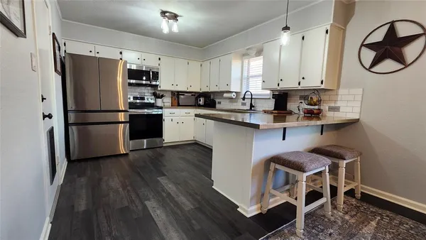 a kitchen with stainless steel appliances a stove a sink refrigerator and cabinets