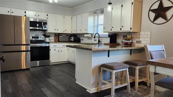 a kitchen with stainless steel appliances granite countertop a white cabinets and a stove