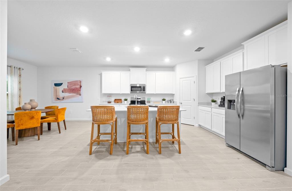 6880 Southwest 87th Street Ocala, FL 34476 - Photo 21 of 36 a kitchen with a refrigerator and a dining table