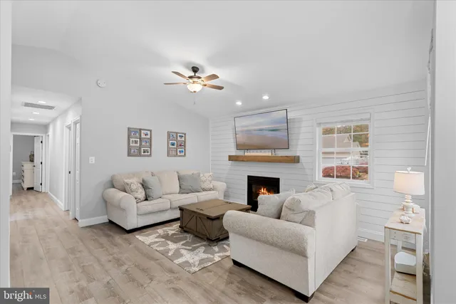 a living room with stainless steel appliances kitchen island furniture and a chandelier