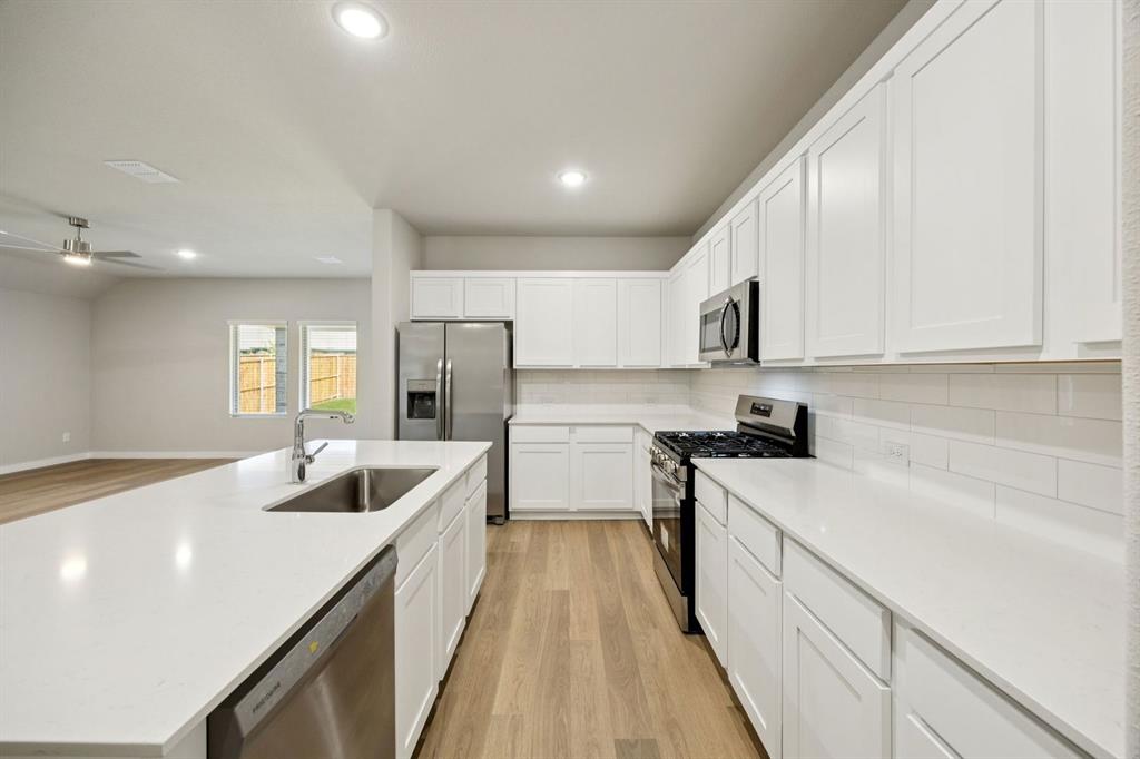 521 Sierra Ridge Lavon, TX 75166 - Photo 6 of 29 a kitchen with a sink stove top oven and refrigerator