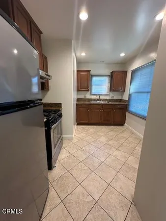 a large kitchen with a stove a refrigerator and a sink