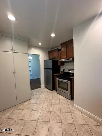 a kitchen with granite countertop a refrigerator and a stove top oven