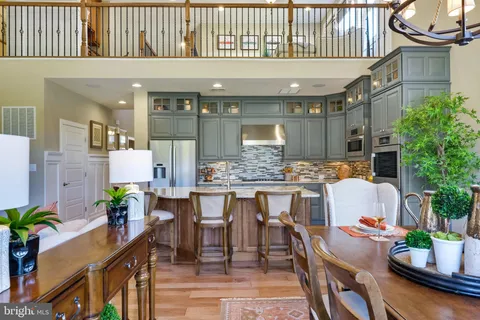 a dining room with stainless steel appliances granite countertop a couch and wooden floor
