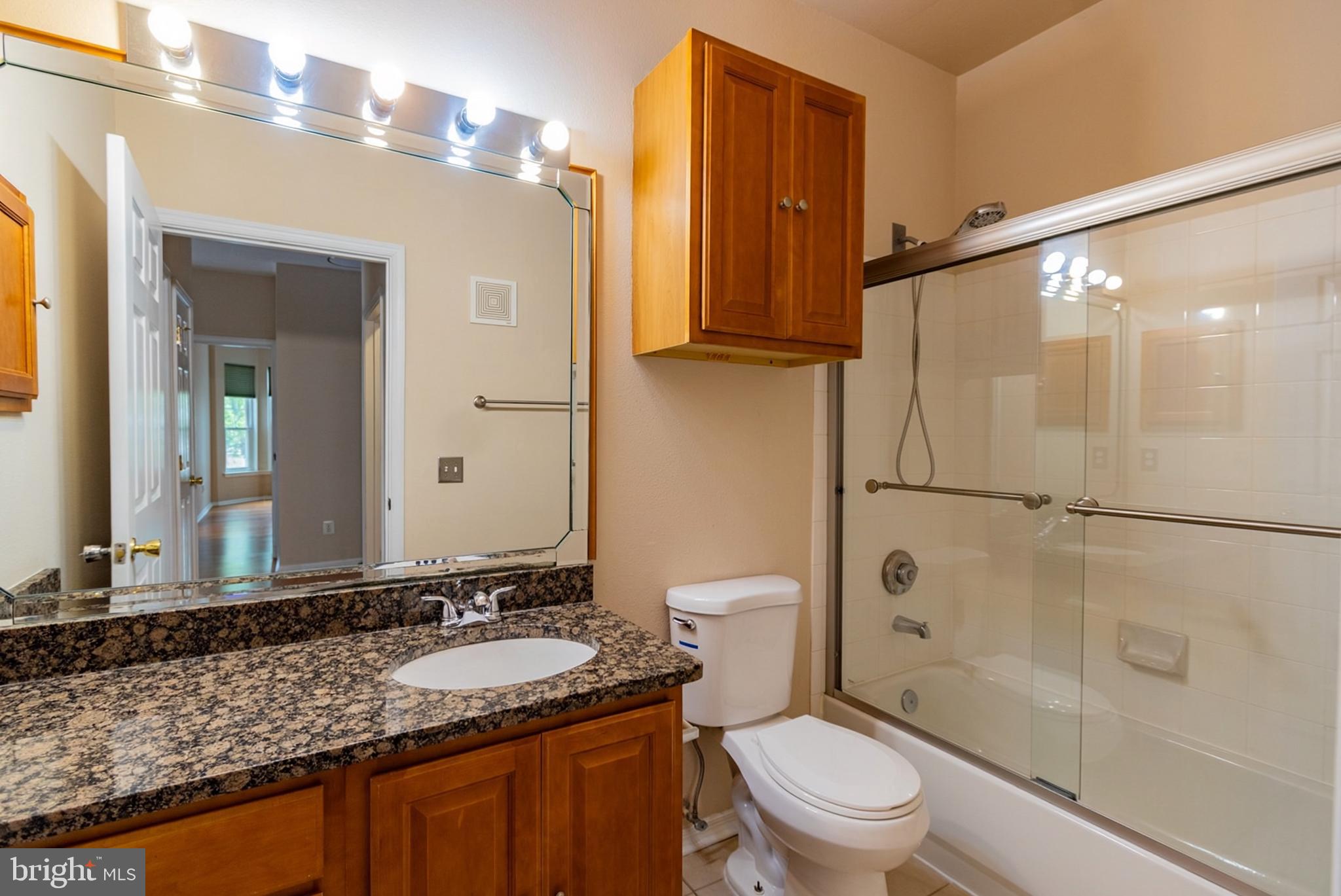 1600 Spring Gate Dr., Unit 2207 McLean, VA 22102 - Photo 24 of 32 a bathroom with a granite countertop sink toilet and shower