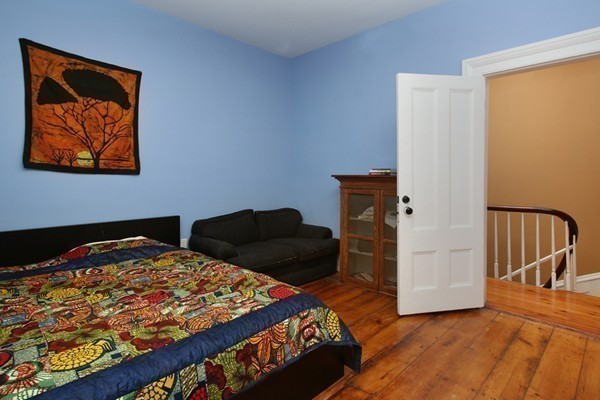 88 Lambert Avenue Boston, MA 02119 - Photo 14 of 19 a bedroom with a bed and wooden floor