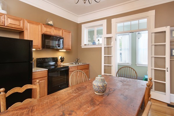 88 Lambert Avenue Boston, MA 02119 - Photo 9 of 19 a kitchen with stainless steel appliances granite countertop a stove a sink dishwasher a refrigerator and white cabinets with wooden floor